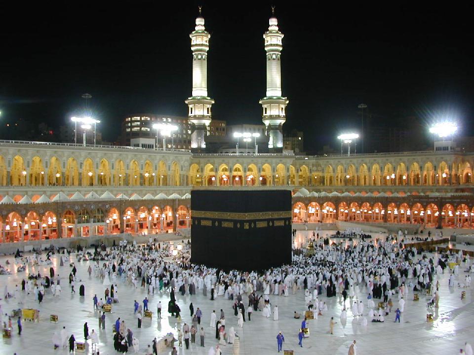 The Kaaba in the Masjid al-Haram, Makkah, at night surrounded by worshippers